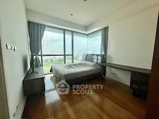 Spacious bedroom with large windows and wooden flooring