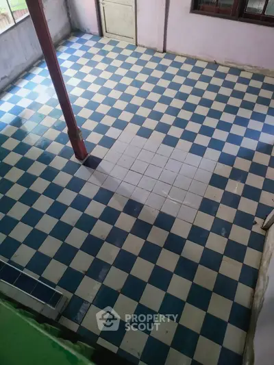 Spacious tiled area with checkered blue and white flooring, ideal for versatile use.