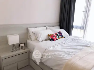 Cozy bedroom with modern decor and natural light, featuring a stylish bed and elegant bedside table.