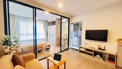 Modern studio apartment with glass partition, cozy living area, and stylish kitchen.