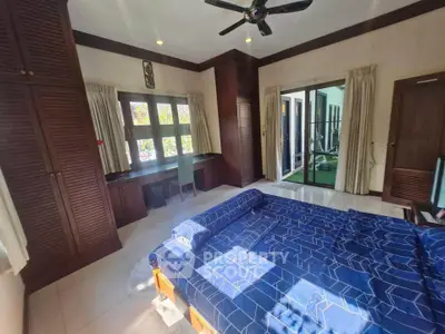 Spacious bedroom with wooden accents and garden view, perfect for relaxation.