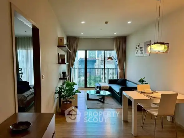 Modern living room with city view, featuring sleek furniture and stylish decor in a high-rise apartment.