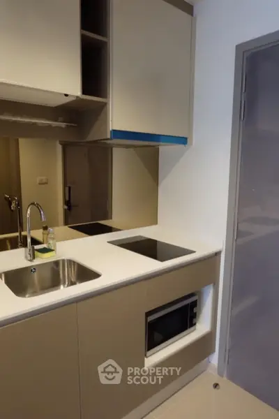 Modern compact kitchen with sleek cabinetry and built-in appliances