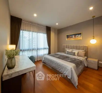 Luxurious bedroom with elegant decor and large window for natural light.