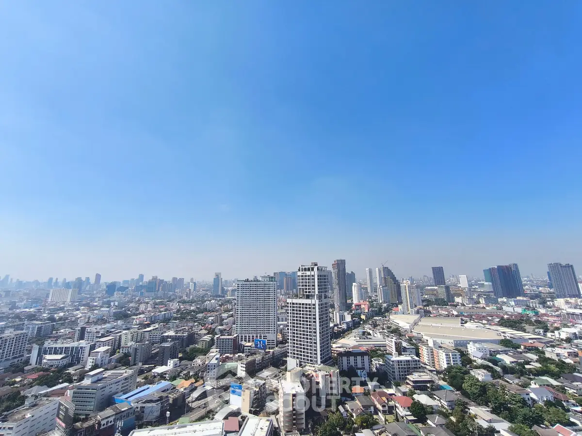 Stunning cityscape view from a high-rise building showcasing urban skyline and clear blue sky.
