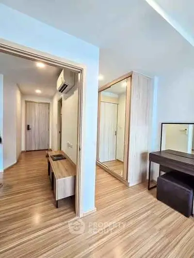 Modern apartment interior with wooden flooring and mirrored wardrobe