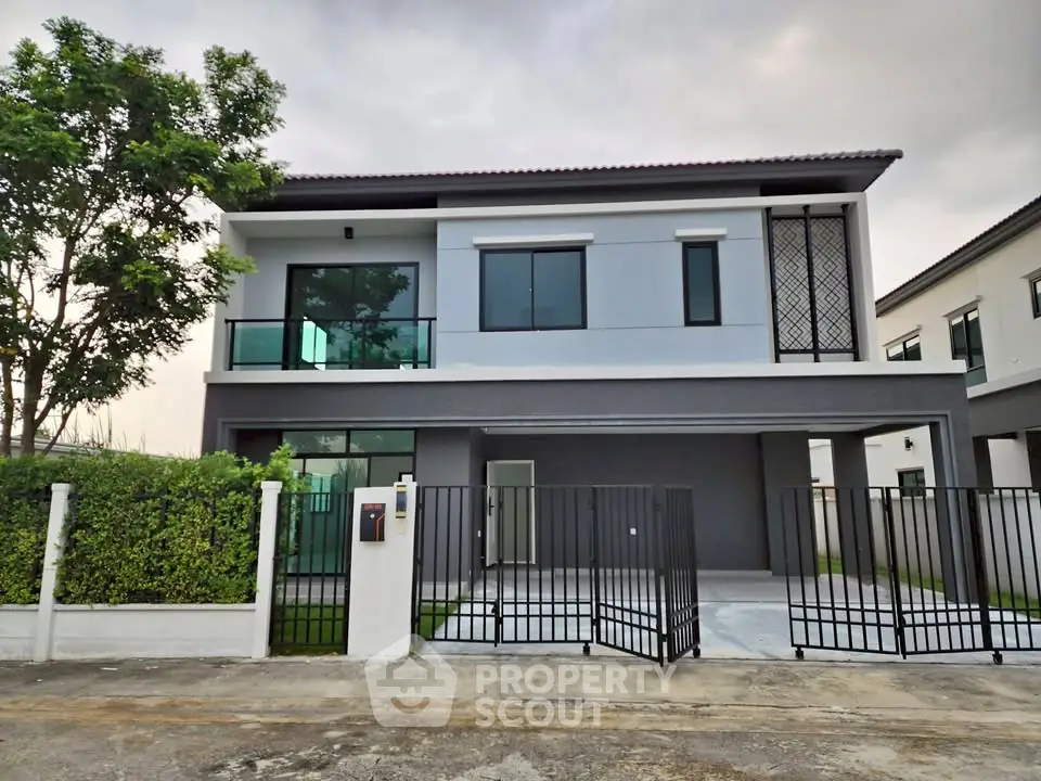 Modern two-story house with sleek design and spacious driveway in a serene neighborhood.