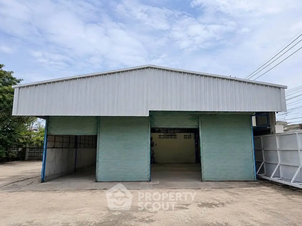 Spacious industrial warehouse with large entry doors and ample outdoor space.