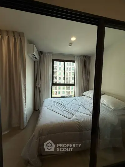 Cozy bedroom with large window and modern decor in urban apartment
