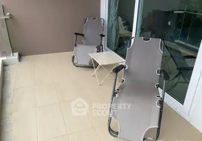 Spacious balcony with modern chairs and table, perfect for relaxation.