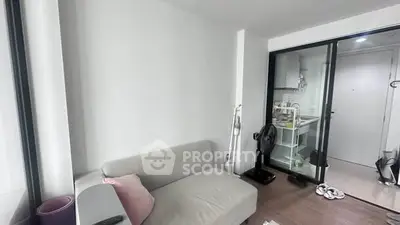 Modern living room with sleek sofa and open kitchen layout in a stylish apartment.