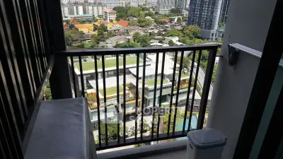 Stunning high-rise balcony view overlooking cityscape and lush greenery, perfect for urban living.