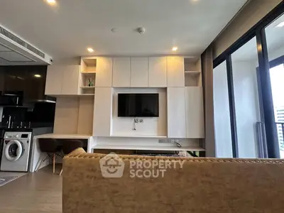 Modern living room with built-in TV, washing machine, and balcony access in a stylish apartment.