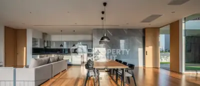Spacious modern living room with open kitchen and elegant dining area, featuring sleek design and natural light.