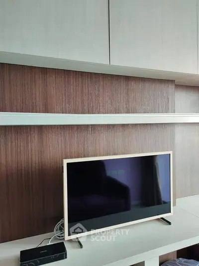 Modern living room with sleek TV and stylish wooden paneling