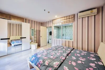 Spacious bedroom with floral bedding and mirrored wardrobe in modern apartment