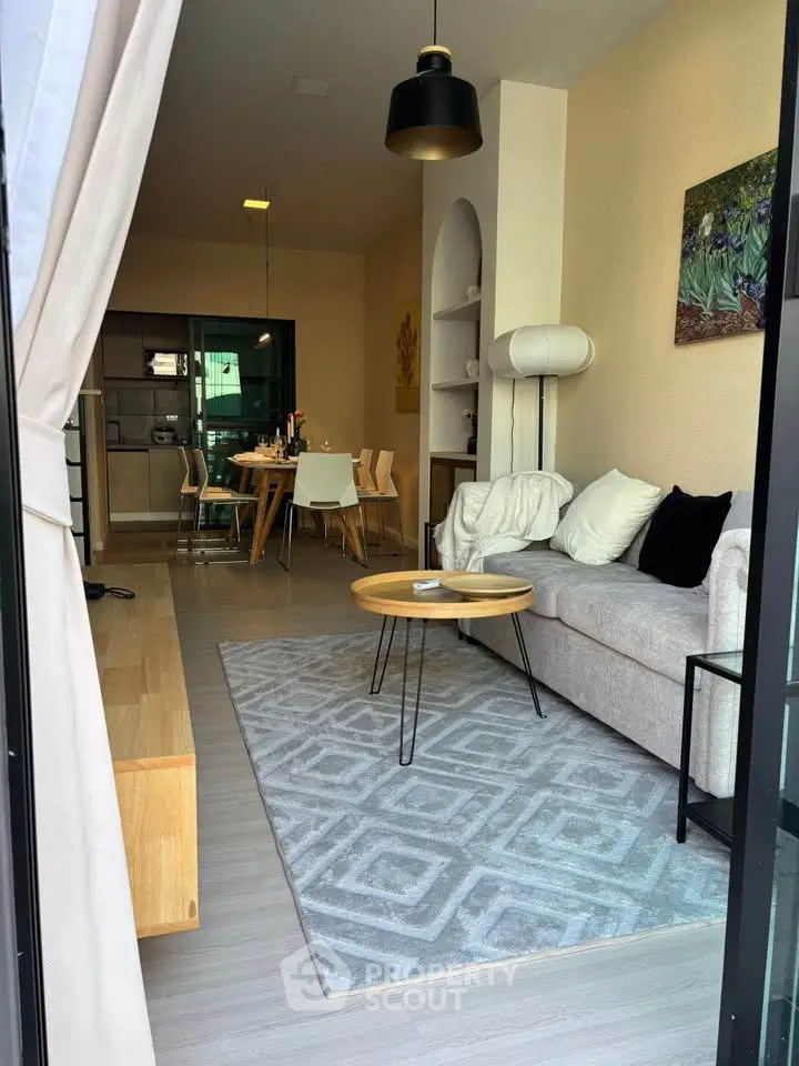 Stylish modern living room with cozy seating and elegant dining area in open layout.