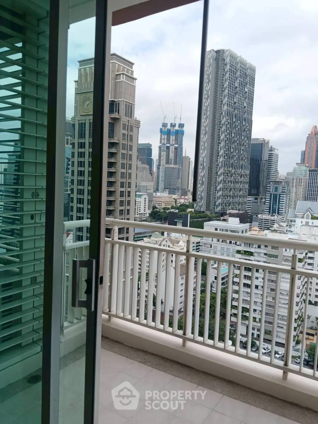 Stunning cityscape view from high-rise balcony with modern architecture.