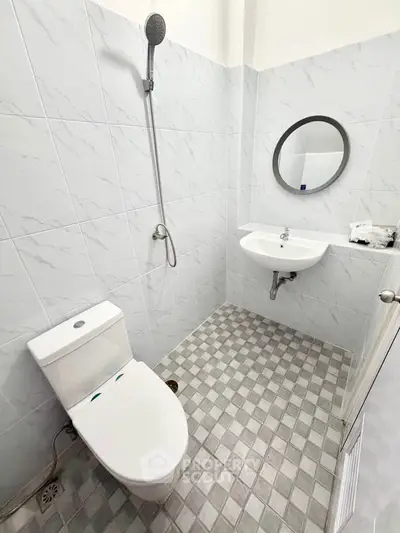 Modern bathroom with sleek white fixtures and stylish tiled flooring.