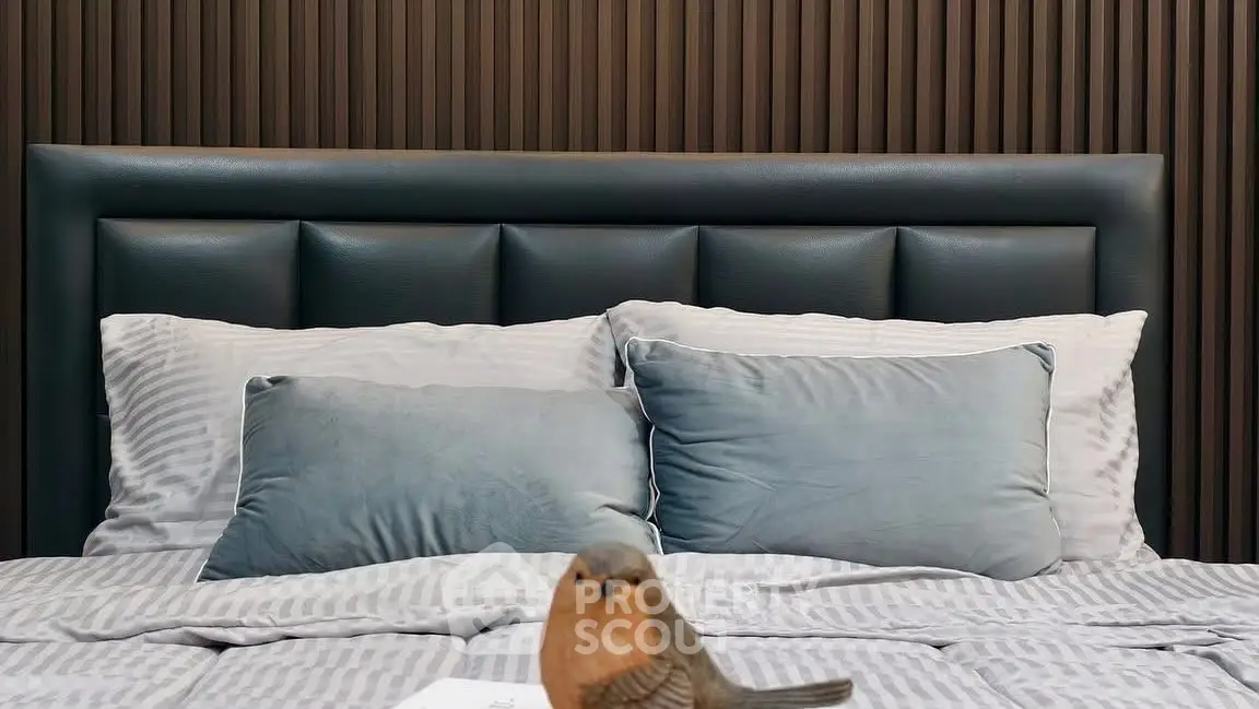 Luxurious bedroom with plush bedding and elegant headboard design.