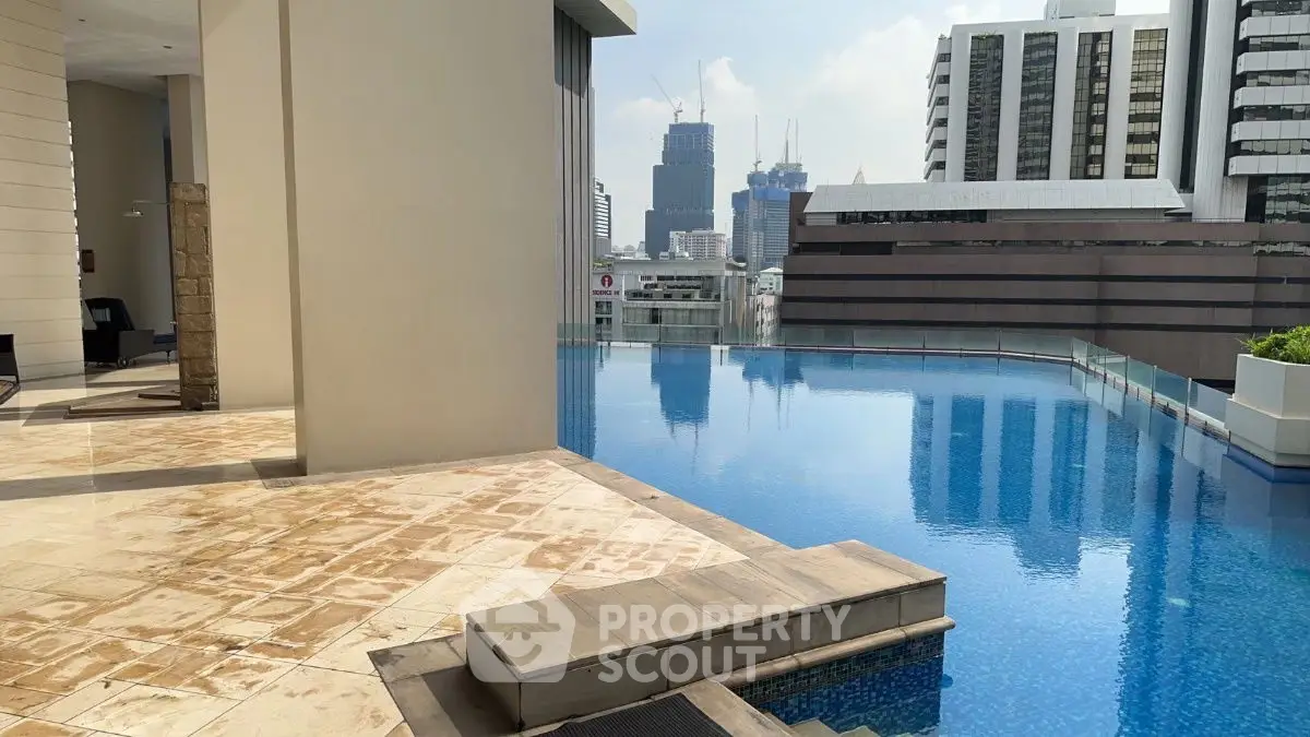 Luxurious rooftop pool with stunning city skyline views in a modern high-rise building.