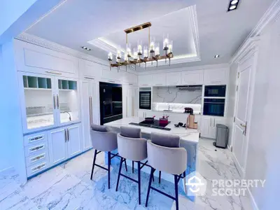 Luxurious modern kitchen with marble island and elegant chandelier