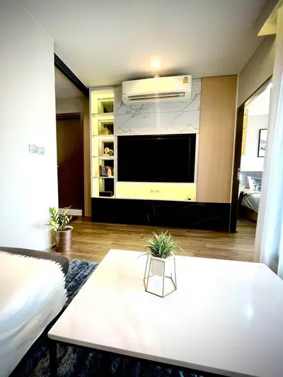 Modern living room with sleek design, featuring a wall-mounted TV and stylish decor.