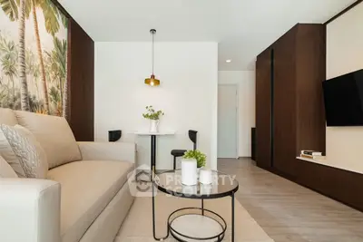 Modern living room with stylish decor and cozy seating area, featuring a tropical accent wall and sleek furniture.