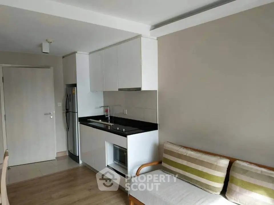 Modern apartment kitchen with sleek cabinetry and cozy seating area.