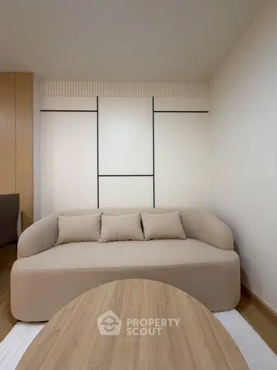 Modern living room with minimalist beige sofa and wooden coffee table, perfect for cozy relaxation.