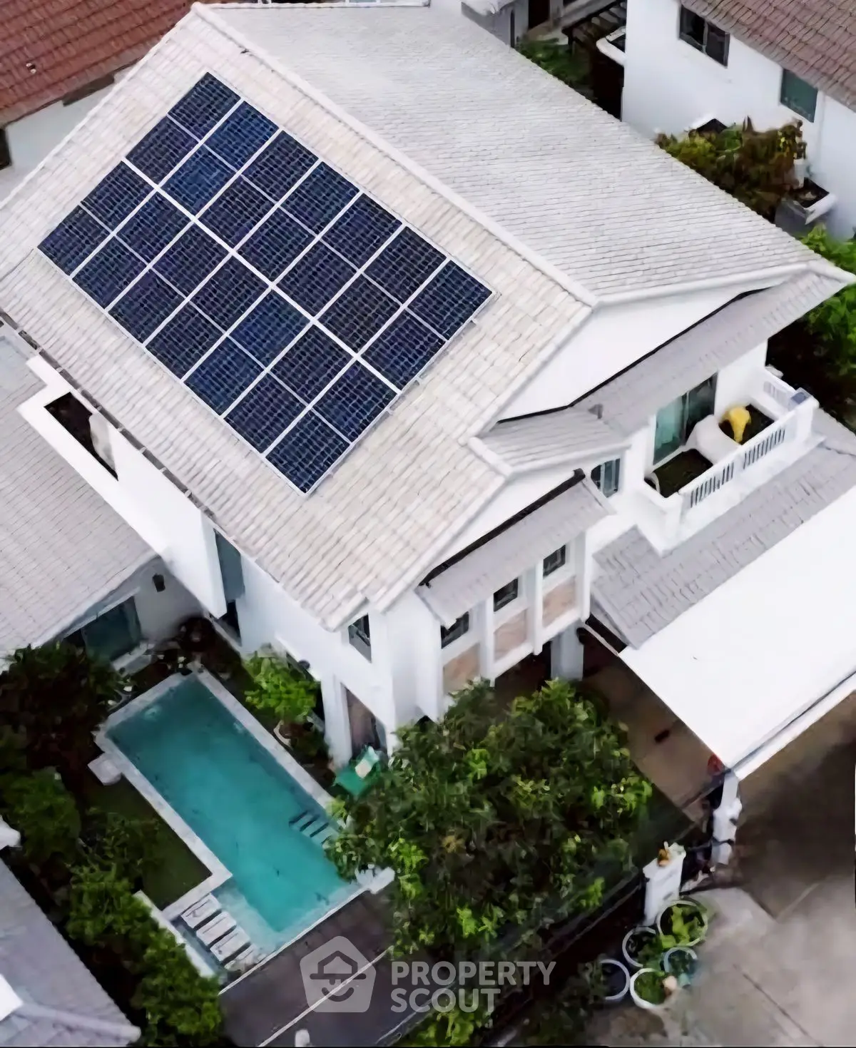 Modern eco-friendly home with solar panels and private pool in lush garden setting.