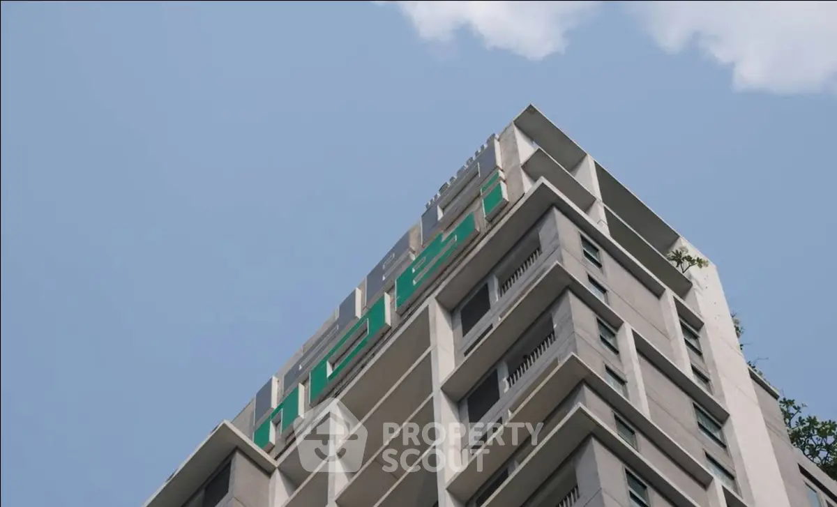 Modern high-rise building with sleek architectural design against a clear blue sky.