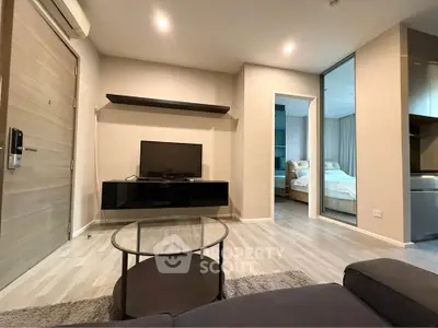 Modern living room with sleek furniture and open view into a cozy bedroom, showcasing contemporary design.
