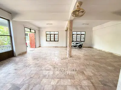 Spacious tiled garage with natural light and scooter parking