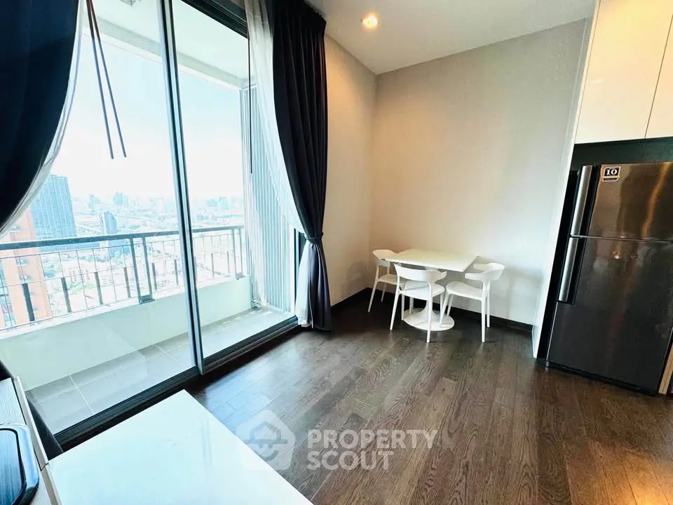 Modern apartment with balcony and city view, featuring sleek kitchen and dining area.
