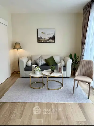 Stylish living room with modern decor, cozy sofa, elegant coffee tables, and natural light.