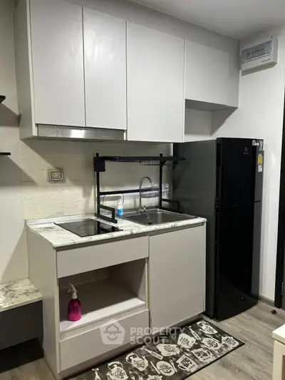 Modern compact kitchen with sleek cabinets and black appliances