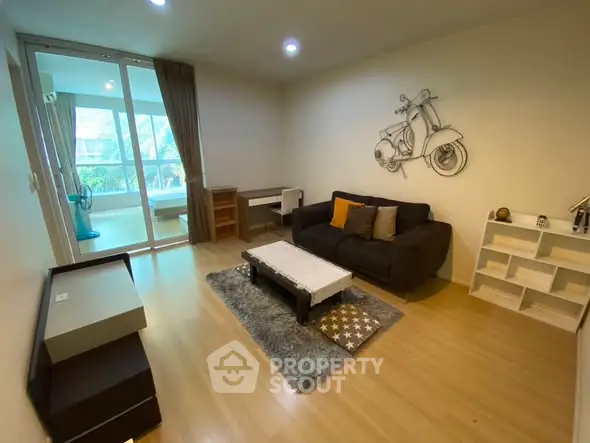 Modern living room with stylish decor and balcony access, featuring cozy seating and unique wall art.