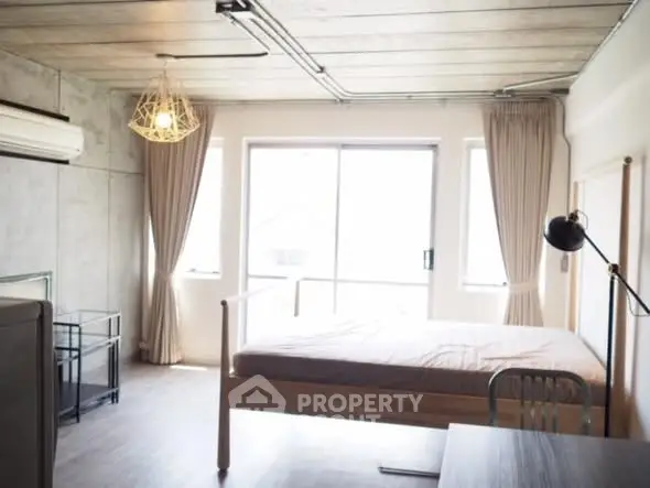 Modern bedroom with large windows and stylish lighting in a contemporary apartment.