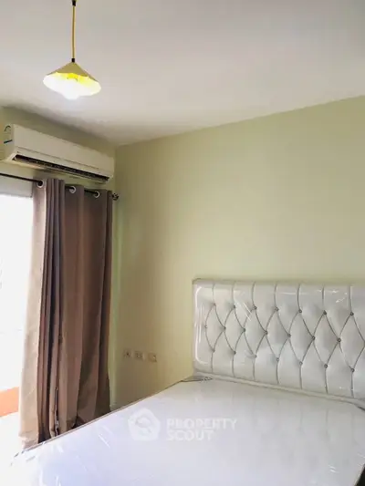 Cozy bedroom with elegant tufted headboard and air conditioning, perfect for restful nights.
