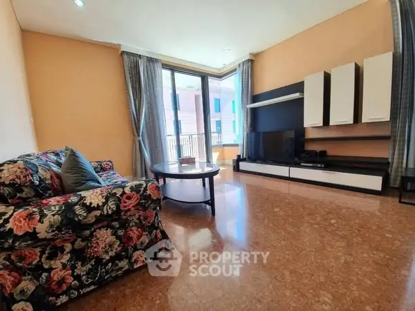 Spacious living room with floral sofa and modern entertainment unit