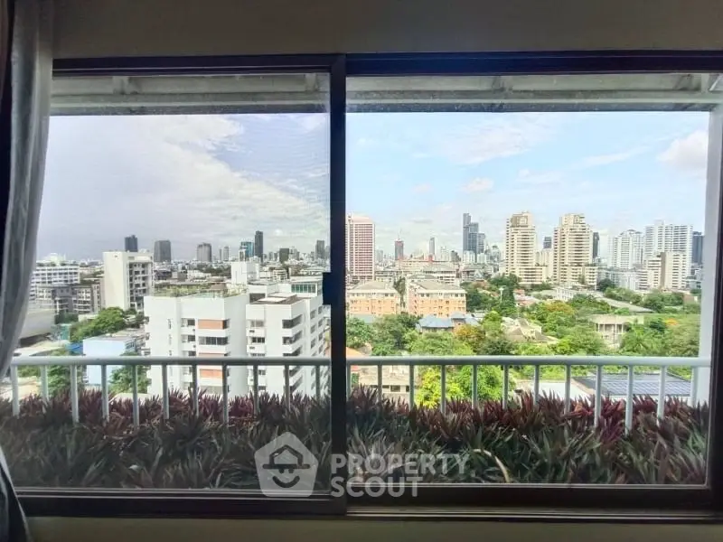 Stunning cityscape view from high-rise apartment window with lush greenery and skyline.