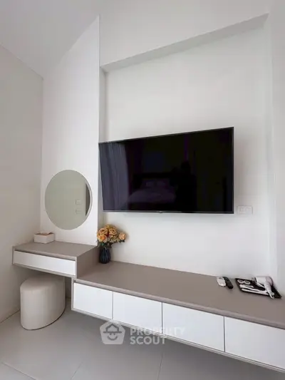 Modern living room with wall-mounted TV and sleek storage unit
