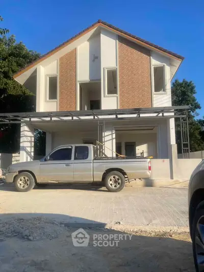 Modern two-story house with a sleek design and spacious driveway.