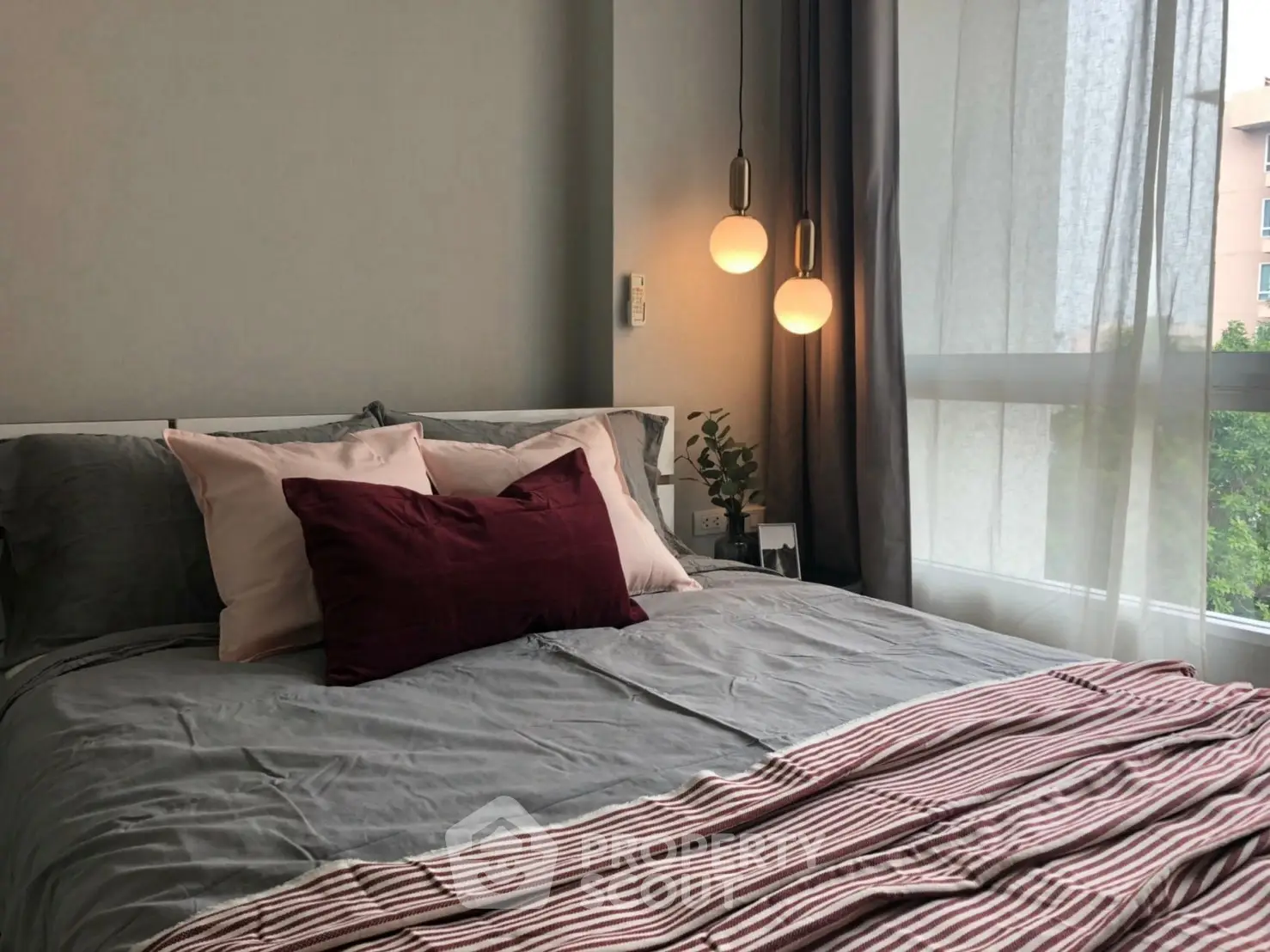 Cozy bedroom with modern decor and large window offering natural light