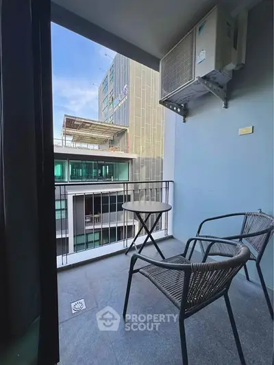 Chic urban balcony with modern seating and city view, perfect for relaxation and enjoying the skyline.