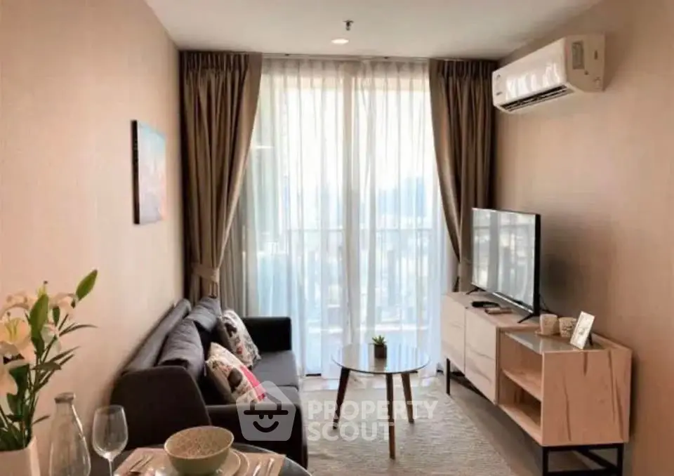 Cozy living room with modern decor and natural light, featuring a comfortable sofa and flat-screen TV.