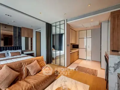 Modern open-plan living room and kitchen with stylish decor and cozy bedroom view.