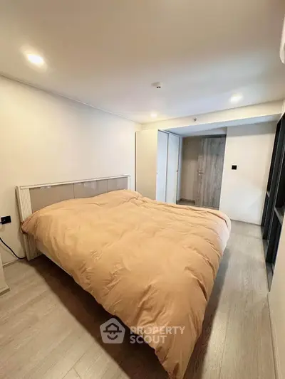 Spacious bedroom with modern design and cozy ambiance, featuring a large bed and sleek flooring.