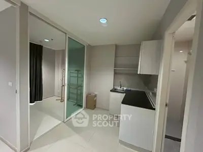 Modern apartment with sleek kitchen and glass partitioned area, ideal for urban living.